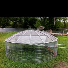 a chicken coop in the middle of a grassy field