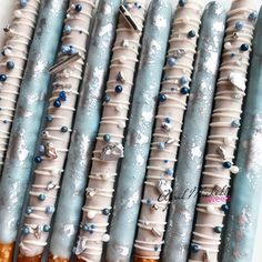 several blue and white candles with frosting on them are lined up in a row