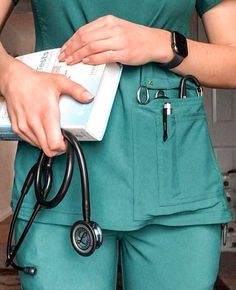 a woman in green scrubs holding a medicine box and a stethoscope