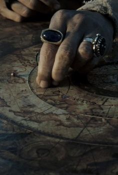 a person's hand on top of a map with rings around it and an arrow in the middle