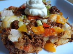 a close up of a piece of food on a plate with cheese and other toppings