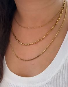 Elevate your style with our stunning triple-layered necklace. Crafted with high-quality stainless steel and plated in 18K gold, this necklace features a trendy paperclip box chain design. The three layers create a chic and sophisticated look that's perfect for any occasion. Versatile and easy to wear, this necklace adds an instant touch of glamour to any outfit. Make a bold fashion statement with our exquisite triple layer necklace. Dainty Stainless Steel Chain Necklace With Delicate Chain, Dainty Stainless Steel Necklace With Delicate Chain, Layer Chain Necklace, Triple Layer Necklace, Thick Gold Chain, Jewellery Photography Inspiration, Minimalist Chain, Layer Chain, Layered Chain Necklace