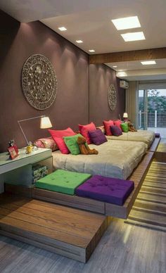 a living room filled with lots of furniture and colorful pillows on top of it's couches