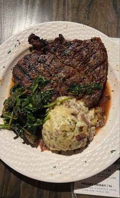 steak, mashed potatoes and greens on a white plate