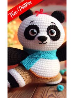 a crocheted panda bear sitting on top of a wooden table