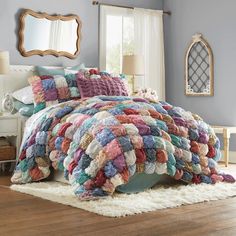 a bed covered in lots of colorful pillows