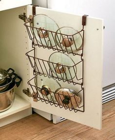 pots and pans are stored in a rack on the shelf next to an oven