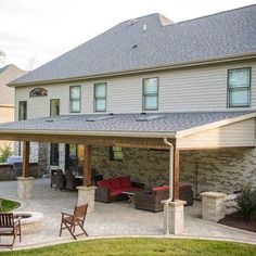 an outdoor living area with patio furniture and fire pit in the middle of the yard