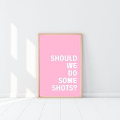 a pink poster with the words should we do some shots? against a white wall