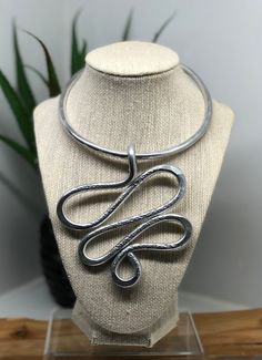 This silver wire necklace has a oversized, curvy and unique pendant.  It is made of aluminum and light weight. Note:  All of my pieces are handmade and especially made to order for my customers.  Each piece will be uniquely designed for you and therefore may vary (slightly) from what is pictured. Silver Spiral Metal Necklaces, Silver Spiral Metal Necklace, Artistic Silver Wire Wrapped Necklaces, Artistic Silver Wire Wrapped Necklace, Artsy Silver Jewelry With Large Pendant, Artsy Silver Necklace With Large Pendant, Artsy Adjustable Silver Necklace, Adjustable Silver Artsy Necklaces, Adjustable Silver Artsy Necklace