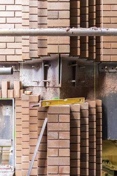 a pile of bricks sitting on top of a floor next to a building under construction