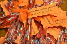 some candy sticks are wrapped in orange paper and have writing on them that read, leave the yellow jacketet in a twizzle