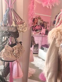 there are many purses hanging on the rack in this room and one is pink