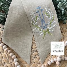 Our 100% linen sashes are a lovely accent to a plain boxwood wreath and can be easily changed out for the seasons.  They make a perfect topper for Easter baskets, bouquet wraps, home decor and even newborn photography sessions. The sashes measure 5" wide x 56" long. Our sashes are embroidered before being stitched together.  We do no use embroidery blanks.  The back of your sash will not show any embroidery stitches.  (Wreath/Basket shown in photos not included) This lily of the valley crest exudes such understated elegance.  A gorgeous embroidery design that lends itself beautifully at a bridal shower or wedding.  Equally stunning on your front door year-round.  Our example is shown embroidered with white, fresh green and cornflower blue thread on oatmeal linen. You may choose your own co Monogram Gift Ideas, Wreath Sashes, Linen Decor, Wreath Sash, Crest Monogram, Embroidery Blanks, Boxwood Wreath, Bouquet Wrap, Monogram Wreath