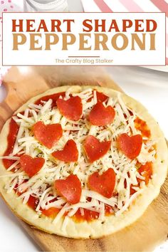 heart shaped pepperoni pizza on a wooden cutting board