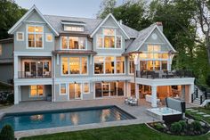 a large house with a pool in front of it and lots of windows on the side