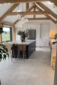 a large kitchen with an island in the center and two stools next to it