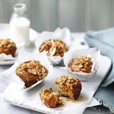 some muffins are sitting on a white plate and next to a glass of milk