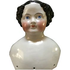 a white ceramic busturine with black hair and blue eyes