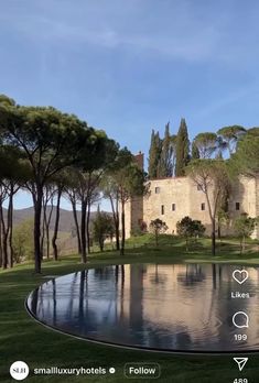 an image of a house that is in the middle of some trees and grass with its reflection on the water