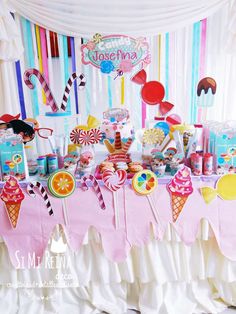 a table topped with lots of candy and lollipops on top of it