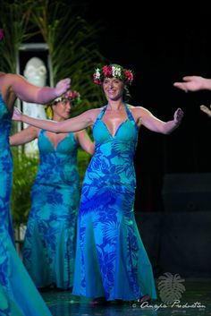 three women in blue dresses dancing on stage