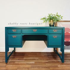 a blue desk with a potted plant on top and a sign above it that says shabby roots boutique