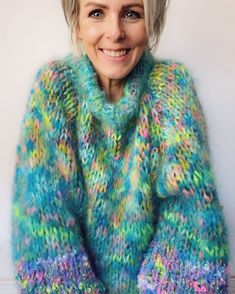 a woman with blonde hair wearing a colorful sweater