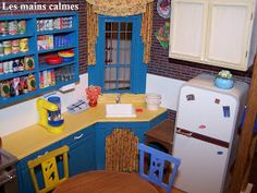 a doll house kitchen with blue cabinets and yellow counter tops