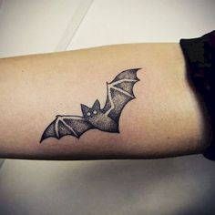 a small bat tattoo on the arm