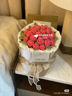 a bouquet of red roses in a box on a bed