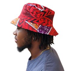 A unisex bucket cap made using authentic Ankara fabric. 58cm. Ankara, also known as African wax print or Dutch wax print, is a fabric characterized by vibrant patterns and colors. The fabric is made through a wax-resist dyeing technique called batik which creates distinct and colorful patterns. Ankara fabric is used to make a wide range of clothing and accessories, including dresses, skirts, shirts, and hats. Each pattern carries cultural meanings and stories making pieces made from this fabric not just fashion items but also carriers of African heritage and identity. Casual Multicolor Cotton Bucket Hat, Casual Red Sun Hat For Festival, Casual Multicolor Bucket Hat For Streetwear, Multicolor Cotton Hat For Streetwear, Reversible Multicolor Cotton Sun Hat, Red Wide Brim Bucket Hat For Festival, Multicolor Reversible Cotton Sun Hat, Adjustable Red Bohemian Bucket Hat, Red Festival Bucket Hat