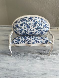 a blue and white couch sitting on top of a wooden floor