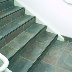 an image of a stair case going up to the top floor with tile on it