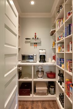 a kitchen pantry with lots of food and drinks on the shelves in front of it