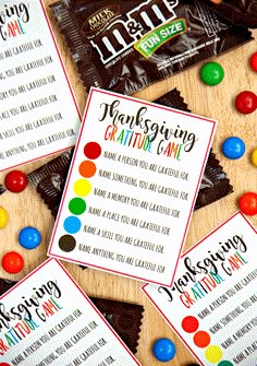 some candy bar wrappers are sitting on top of a wooden table with colorful candies