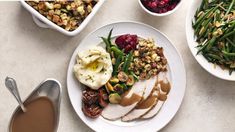 a table topped with plates of food and bowls of vegetables next to cups of coffee