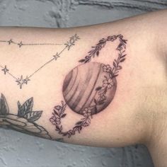 a close up of a person's arm with a tattoo on it and flowers around the arm