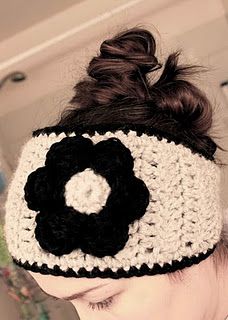 a woman wearing a black and white crochet headband with a flower on it