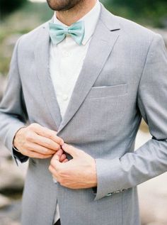 a man wearing a gray suit and bow tie