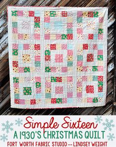 a christmas quilt hanging on the side of a wooden fence with snowflakes around it