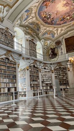 a large room filled with lots of books on top of a checkerboard floor