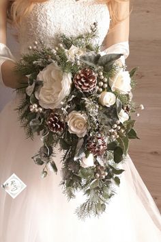 a bridal holding a bouquet of flowers and pine cones