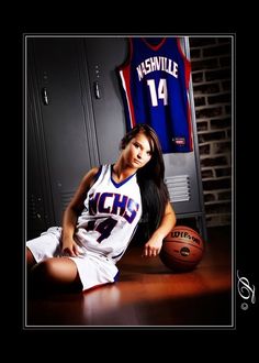 a woman sitting on the floor next to a basketball