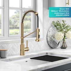 an image of a kitchen sink with gold faucet and white marble countertop