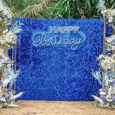 a blue and white birthday backdrop with flowers