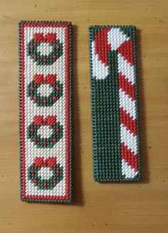 two christmas themed bookmarks sitting on top of a wooden table