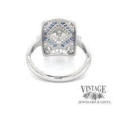 a white gold ring with blue and white diamonds in the center, on a white background