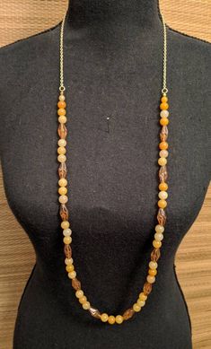 This beautiful and unique beaded necklace measures 36inches and is made with 8mm round yellow jade beads and 10mm spiral glass yellow/brown beads. Yellow Jade brings joy, happiness, and self-confidence.  It is a protective stone that symbolizes wealth, good fortune, friendship, and loyalty.  It is also used to provide emotional stability, loving relationships, good luck, wisdom, protection, and longevity of life.  It can be used to help problems with the kidney, heart, larynx, spleen, thyroid, b Brown Long Necklace With Colorful Beads For Gift, Gift Brown Long Necklace With Colorful Beads, Gift Long Brown Necklace With Colorful Beads, Yellow Spiritual Beaded Necklace With Gemstone Beads, Brown Long Necklace With Colorful Beads, Brown Beaded Long Necklace For Gift, Brown Beaded Long Necklace Gift, Yellow Necklaces With Natural Round Beads, Spiritual Brown Beaded Chain Necklaces