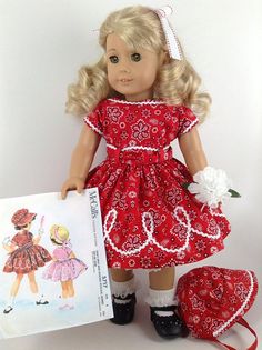 a doll with blonde hair holding a book next to it's matching outfit and shoes